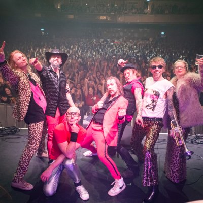 Terrorvision band on stage with crowd in colourful costumes